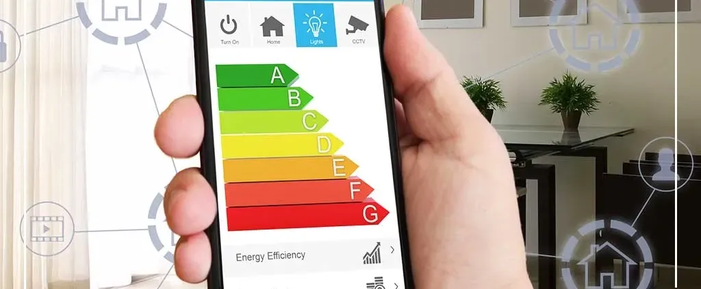 A hand holds a smartphone displaying an energy efficiency chart, labeled A to G with colors from green to red. The background shows a modern living room.