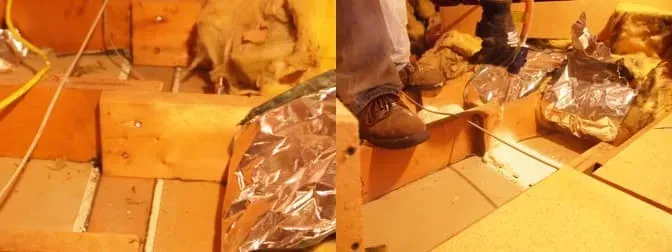An attic space under construction with exposed wooden beams, insulation, and silver ductwork. A person in jeans and boots is stepping carefully.