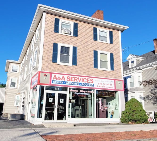 Exterior of a three-story building with a sign "A&A Services: Siding, Windows, Roofing."