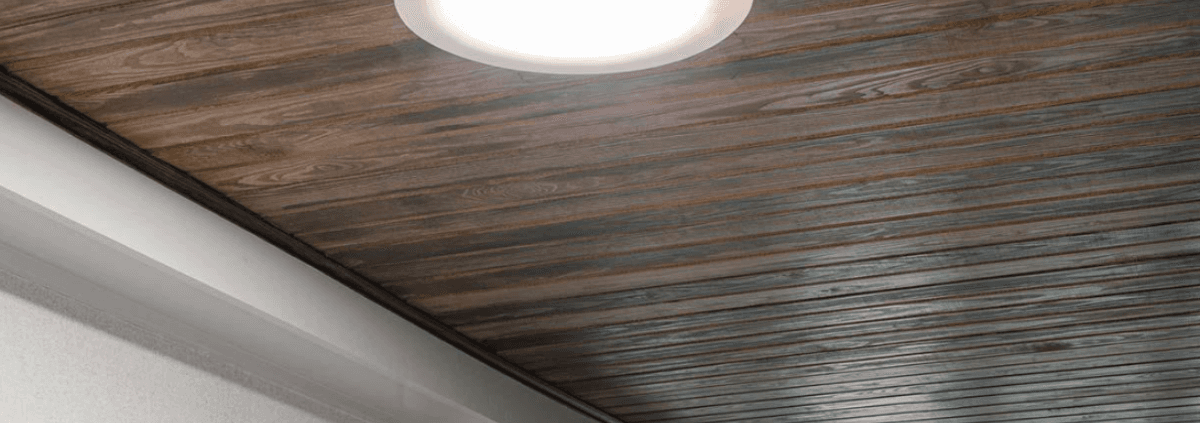 A wooden ceiling with a sleek, contemporary design is lit by a modern, circular ceiling light, creating a warm and inviting atmosphere.
